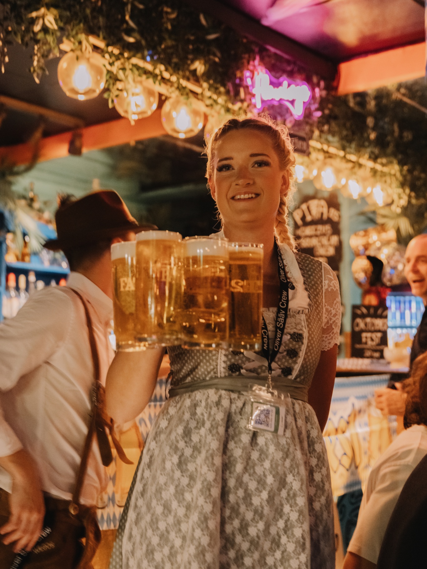 Servitris bär ett fång ölsejdlar under Oktoberfest på Flamingo
