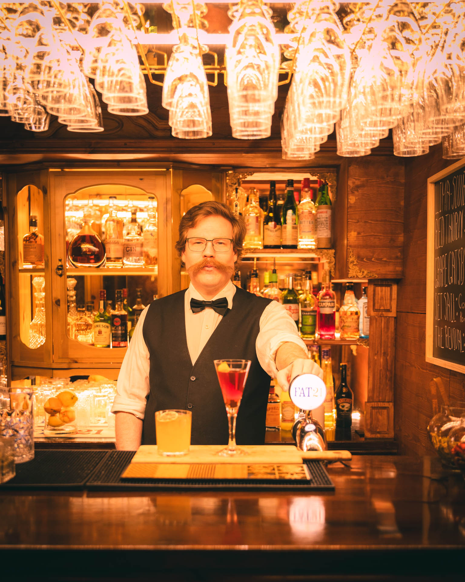 Bartender serverar drinkar bakom Flamingo Bars träbar